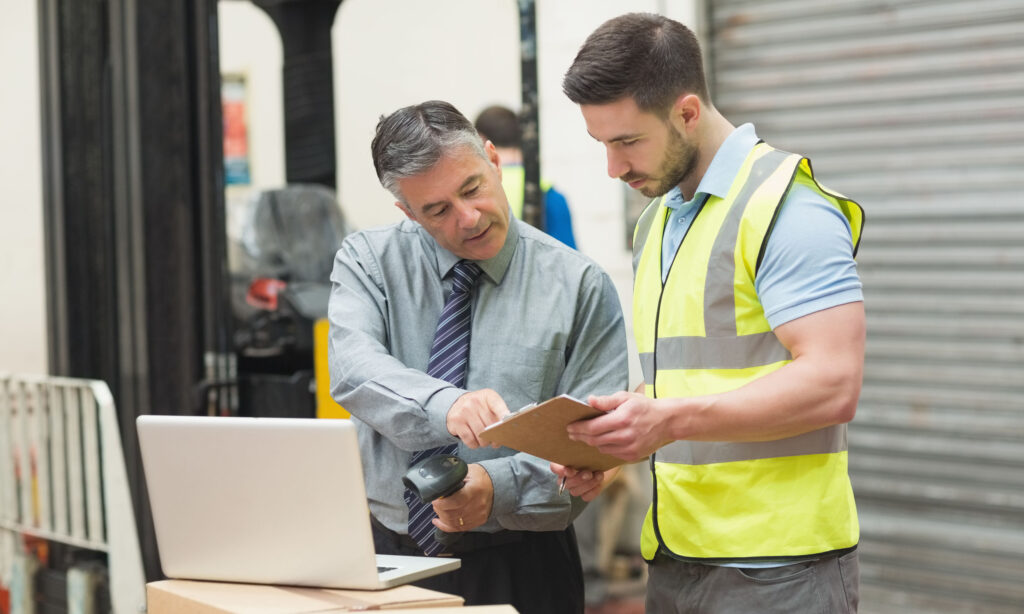 Portrait of manual workers scanning package in the warehouse